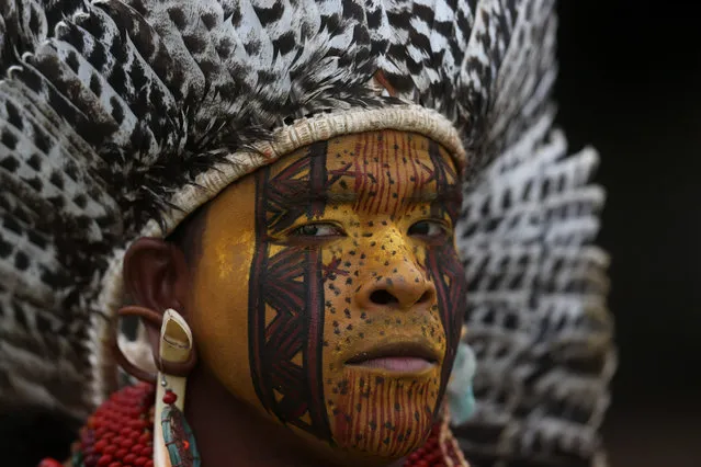 A Pataxo indigenous man attends a soccer match at the World Indigenous Games, in Palmas, Brazil, Friday, October 23, 2015. Hundreds of indigenous people from across Brazil and delegations from as far afield as Mongolia and the Philippines have arrived in Palmas to take part in what's billed as the first "Indigenous Olympics". (Photo by Eraldo Peres/AP Photo)