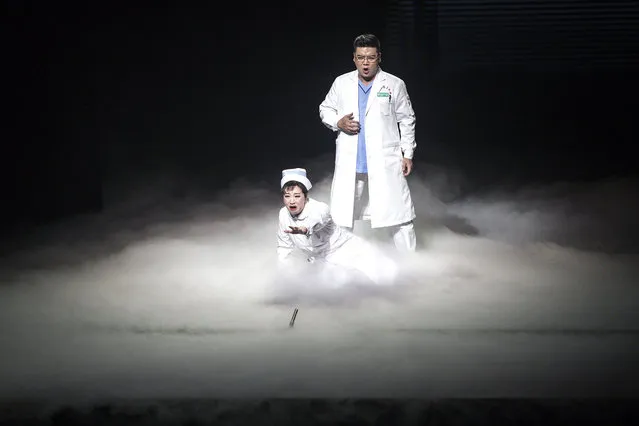 Two cast members perform on stage during the opera “Angel's Diary” on October 18, 2020 in Wuhan, Hubei province, China. The opera, paying tribute to medical staff, portrays the doctor's rescue of coronavirus patients during the lockdown in Wuhan. As there have been no recorded cases of community transmissions since May, life for residents is gradually returning to normal. (Photo by Getty Images/China Stringer Network)
