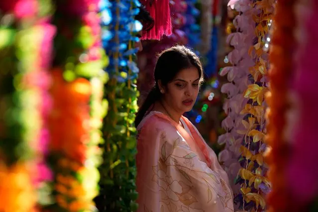 A woman shops on the eve of Diwali, the Hindu festival of lights, in Jammu, India, Sunday, October 23, 2022. Diwali is one of Hinduism's most important festivals, dedicated to the worship of the goddess of wealth Lakshmi. (Photo by Channi Anand/AP Photo)