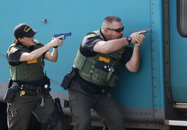 Sheriff officers from San Diego's North County Transit District approach a commuter train while training for an active shooter scenario onboard a train in Oceanside, California December 10, 2014. (Photo by Mike Blake/Reuters)
