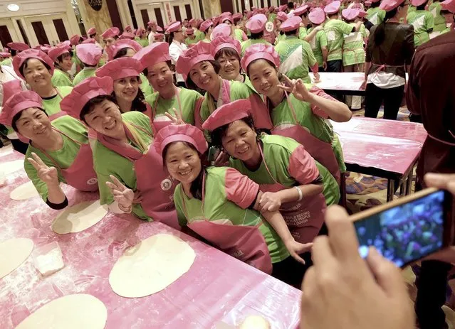 Participants pose for photographs next to pizza dough during an attempt of the Guinness World Record of most people tossing pizza dough, at the Pudong Shangri-La hotel in Shanghai, China, October 28, 2015. (Photo by Reuters/Stringer)
