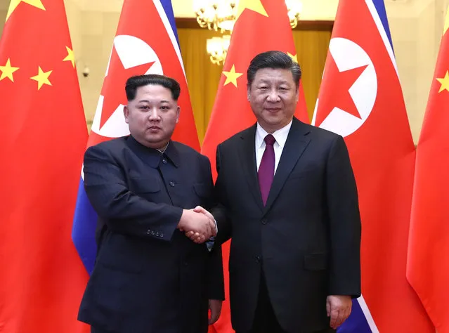 North Korean leader Kim Jong Un and Chinese President Xi Jinping shake hands at the Great Hall of the People in Beijing, China, in this picture released to Reuters on March 28, 2018. (Photo by Ju Peng/Xinhua via Reuters)