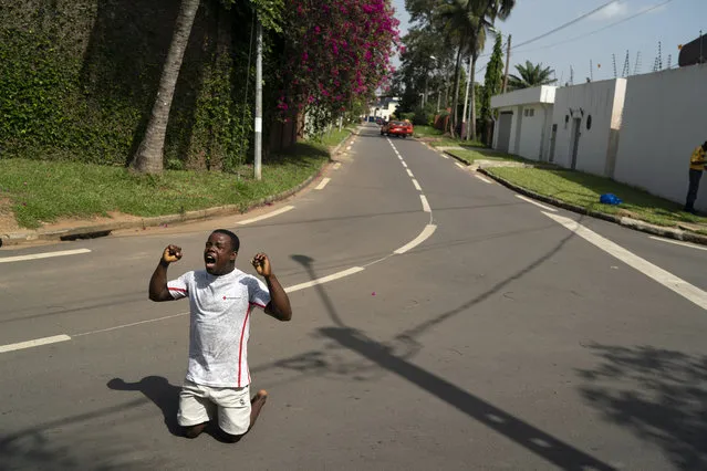 A supporter of the opposition parties shouts asking for peace as riot police are block access to the house of the former president Henri Konan Bedie, in Abidjan, Ivory Coast, Tuesday, November 3, 2020. (Photo by Leo Correa/AP Photo)