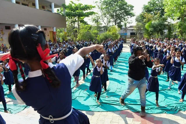 An instructor (front R) leads schoolgirls during a martial arts class for self-defence at a school in Ahmedabad on March 16, 2023. (Photo by Sam Panthaky/AFP Photo)