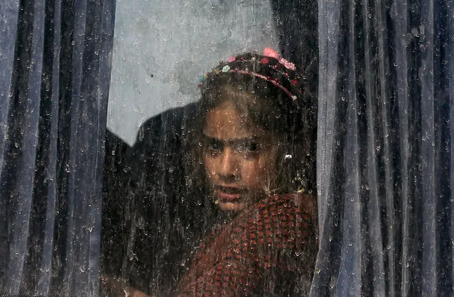 An Iraqi girl sits in a bus transporting displaced families from the displaced persons camp in Habbaniyah in Iraq's Anbar province on November 10, 2020. After five years hosting displaced Iraqis, the vast camp was emptied in under 48 hours. The Habbaniyah Tourist Camp, a former luxury resort used to house Iraqis fleeing the Islamic State group, closed this week as part of a sudden government push to shutter dozens of displacement camps by the end of the year. (Photo by Ahmad Al-Rubaye/AFP Photo)