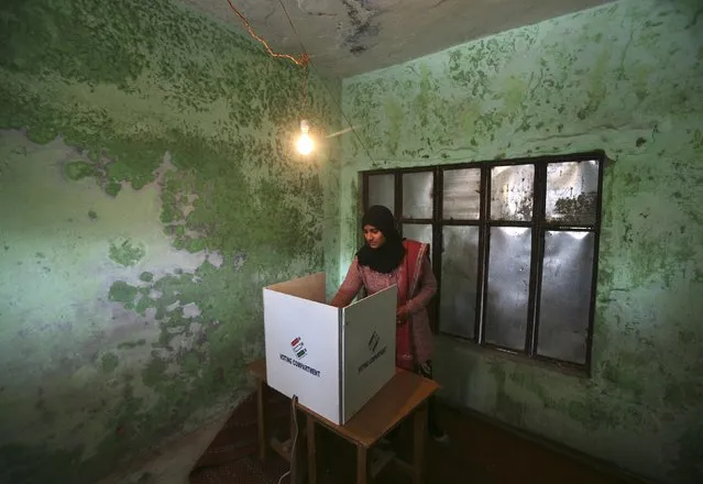 A woman casts her vote at a polling station during the last phase of the Jammu and Kashmir state assembly elections on the outskirts of Jammu December 20, 2014. The five-phased polls in Jammu and Kashmir will end on Saturday and the results would be announced on December 23. (Photo by Mukesh Gupta/Reuters)