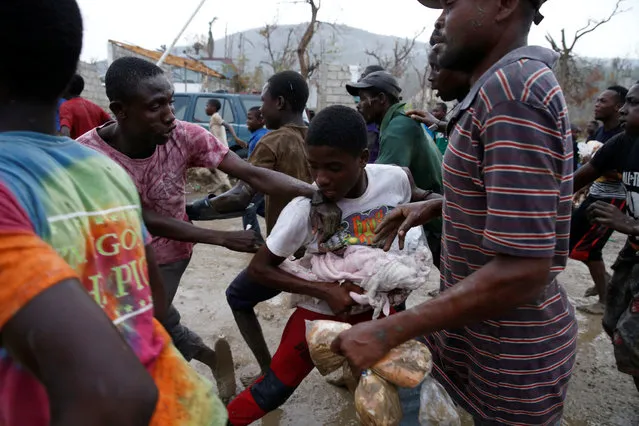 People fight while they assail a truck to try to get food after Hurricane Matthew hit Jeremie, Haiti, October 14, 2016. (Photo by Carlos Garcia Rawlins/Reuters)