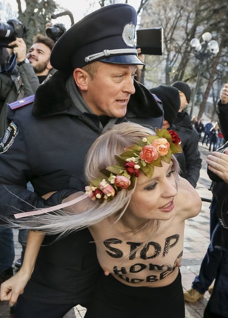 Ukrainian police detain an activist of women's rights group Femen as she protests against homophobia outside the parliament building in Kiev, Ukraine, November 12, 2015. (Photo by Gleb Garanich/Reuters)