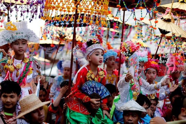 Children are carried on shoulders during an annual Poy Sang Long procession, a traditional rite of passage for boys to be initiated as Buddhist novices, in Mae Hong Son, Thailand, April 3, 2018. (Photo by Jorge Silva/Reuters)