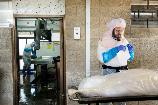 “Hevra Kadisha” workers prepare a body body at a special morgue for COVID 19 before a funeral procession in the city of Holon on December 27, 2020 in Holon, Israel. The country's third national lockdown starts today and will last at least two weeks, depending on the rate of new covid-19 infections. (Photo by Amir Levy/Getty Images)