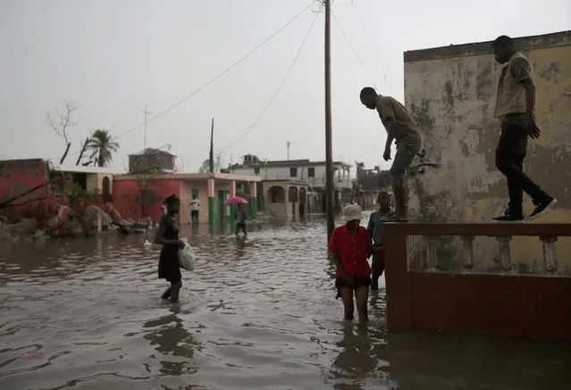 People walk in a flooded street during rain after Hurricane Matthew in Les Cayes, Haiti, October 21, 2016. (Photo by Andres Martinez Casares/Reuters)