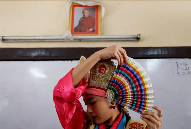 A Tibetan woman adjusts her traditional headgear as she stands near the portrait of spiritual leader Dalai Lama during a function organized to mark “Losar” or the Tibetan New Year in Kathmandu, Nepal on February 23, 2023. (Photo by Navesh Chitrakar/Reuters)