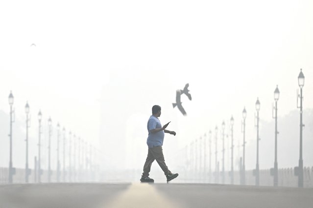 A pedestrian walks amid smog, near India Gate in New Delhi on October 29, 2025. (Photo by Arun Sankar/AFP Photo)