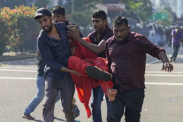 Members of Sri Lankan opposition political party National People's Power carry an injured Buddhist monk during a clash with police in Colombo, Sri Lanka, Sunday, February 26, 2023. The opposition supporters were protesting over a decision to postpone local elections after the government said it cannot finance the same because of the country's crippling economic crisis. (Photo by Eranga Jayawardena/AP Photo)