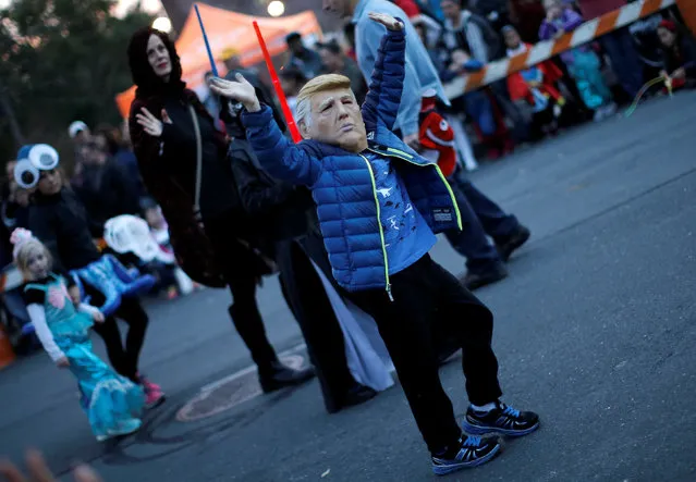 A boy wears a mask of Republican U.S. presidential nominee Donald Trump as he marches in the annual Nyack Halloween Parade in the Village of Nyack, New York, U.S., October 29, 2016. (Photo by Mike Segar/Reuters)