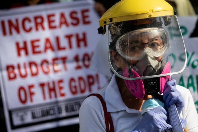 A health worker joins a protest calling for better government response amid the coronavirus outbreak, as the one-year anniversary of the first COVID-19 case in the Philippines approaches, outside a government hospital in Quezon City, Metro Manila, Philippines, January 29, 2021. Protesters said that it has been almost one year since the first reported case of the coronavirus in the country and they are still demanding the government for free mass testing, free vaccines and paid quarantine leave for workers. (Photo by Eloisa Lopez/Reuters)