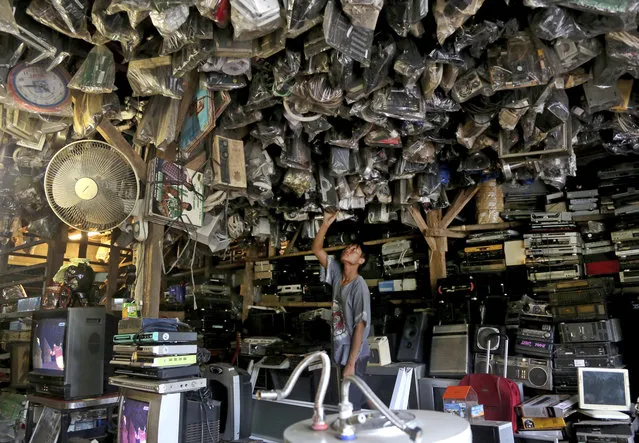 A customer browses through used items at a flea market on the outskirts of Jakarta, Indonesia, Thursday, January 22, 2015. (Photo by Tatan Syuflana/AP Photo)