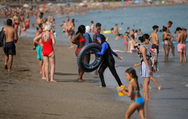 Tourists cool off on La Malagueta beach on a hot summer day during the first weekend of the summer in Malaga, southern Spain, June 24, 2018. (Photo by Jon Nazca/Reuters)