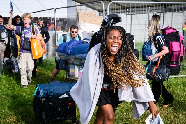 Revellers celebrate as they pass through gates after the 8am public opening of the campsites on Day 1 of Glastonbury Festival 2023 on June 21, 2023 in Glastonbury, England. (Photo by Leon Neal/Getty Images)