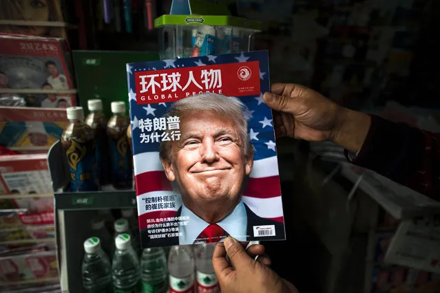 A copy of the local Chinese magazine Global People with a cover story that translates to “Why did Trump win” is seen with a front cover portrait of US president-elect Donald Trump at a news stand in Shanghai on November 14, 2016. Chinese President Xi Jinping and US president-elect Donald Trump agreed November 14 to meet “at an early date” to discuss the relationship between their two powers, Chinese state broadcaster CCTV said. (Photo by Johannes Eisele/AFP Photo)