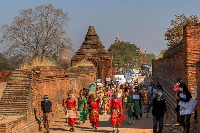 People wearing costumes march with signs in a protest against the military coup in the ancient city of Bagan, Myanmar, February 11, 2021. (Photo by Reuters/Stringer)