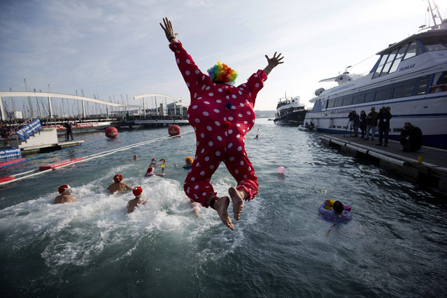 A participant dressed as a clown jumps into the water at the start of the Nadal Cup swimming event at the Port of Barcelona, Spain, 25 December 2015. The swimming event is held annualy at the port to mark Christmas Day. (Photo by Alejandro Garcia/EPA)