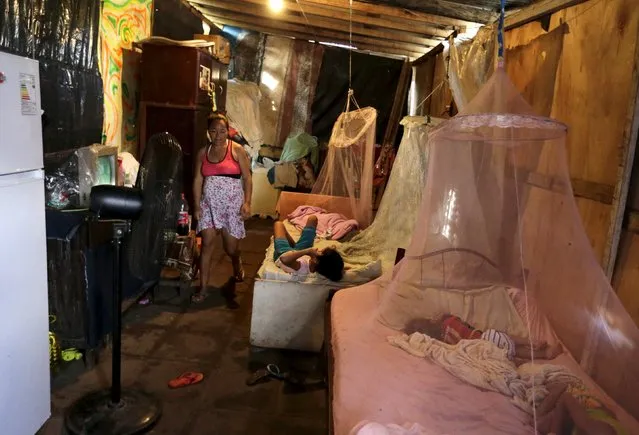 A woman and her sons are seen in a makeshift shelter in Asuncion, December 27, 2015. (Photo by Jorge Adorno/Reuters)