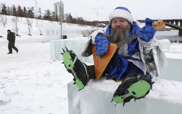 Russian artist Vasily Slonov, dressed as Ded Moroz (Old man Frost or Grandfather Frost) who is the Russian equivalent of Santa Claus, poses for a picture during a performance on an embankment of the Yenisei River in the Siberian city of Krasnoyarsk, Russia, December 29, 2015. Slonov and his assistant organized a performance creating an optical illusion of a “dwarfish” Ded Moroz and marking the upcoming holiday of New Year. (Photo by Ilya Naymushin/Reuters)