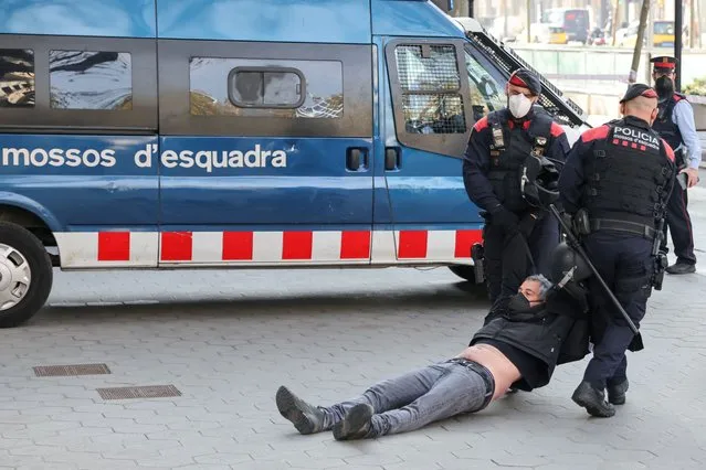 Police officers remove a Catalan separatist from the European Union headquarters, during a protest ahead of the EU summit, in Barcelona, Spain, March 25, 2021. (Photo by Nacho Doce/Reuters)