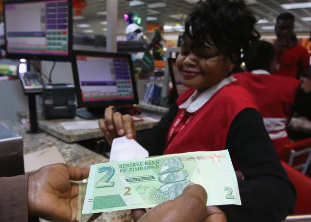 A till operator poses with new bond notes at a supermarket in the capital Harare,Zimbabwe, November 28, 2016. (Photo by Philimon Bulawayo/Reuters)
