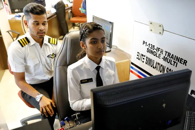 Iram Khan, 17, practices on a flight simulator as her instructor looks on at the Bombay Flying Club's College of Aviation in Mumbai, India, August 28, 2018. Picture taken August 28, 2018. (Photo by Danish Siddiqui/Reuters)