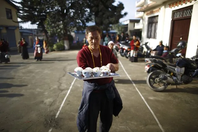 A Tibetan man serves rice during a function organised to mark Losar or the Tibetan New Year at Tibetan Refugee Camp in Lalitpur February 19, 2015. (Photo by Navesh Chitrakar/Reuters)