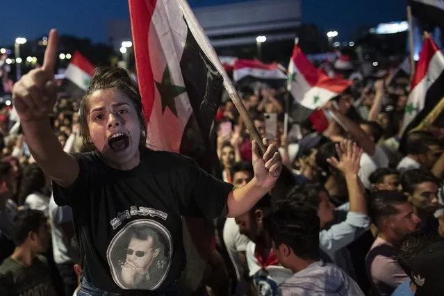 Syrian President Bashar Assad supporters hold up national flags and pictures of Assad as they celebrate at Omayyad Square, in Damascus, Syria, Thursday, May 27, 2021. (Photo by Hassan Ammar/AP Photo)