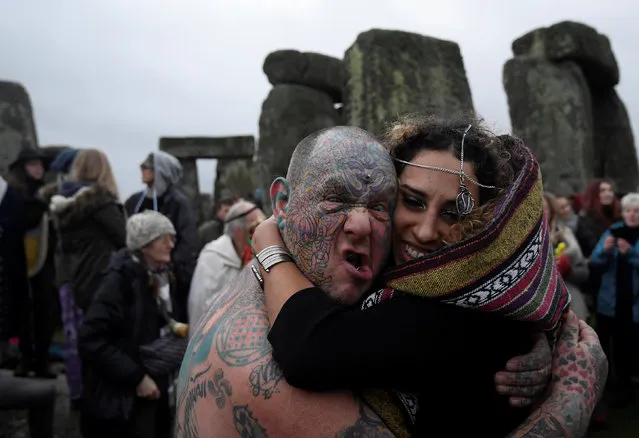 Visitors and revellers react amongst the prehistoric stones of the Stonehenge monument at dawn on Winter Solstice, near Amesbury in south west Britain, December 21, 2016. (Photo by Toby Melville/Reuters)