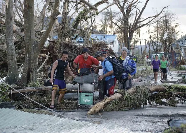 Residents try to seek shelter with their belongings following a powerful typhoon that hit Tacloban city, in Leyte province, central Philippines Saturday November 9, 2013. (Photo by Bullit Marquez/AP Photo)