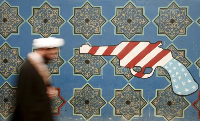 An Iranian cleric walks past a mural on the wall of the former U.S. embassy in Tehran in this file picture taken February 21, 2007. (Photo by Morteza Nikoubazl/Reuters)