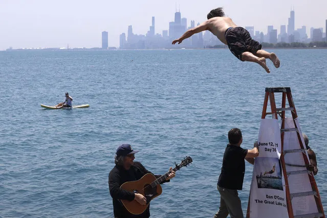 Dan O'Conor, the “Great Lake Jumper”, makes his 365th leap into Lake Michigan, Saturday, June 12, 2021, in Chicago's Montrose Point. (Photo by Shafkat Anowar/AP Photo)