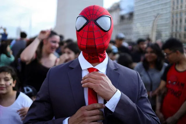 A man dressed as Spider-Man adjusts his tie at a Spider-Man cosplayers' gathering, organised in an attempt to set a Guinness World Record for the largest gathering of people dressed as Spider-Man, in Buenos Aires, Argentina on October 29, 2023. (Photo by Cristina Sille/Reuters)