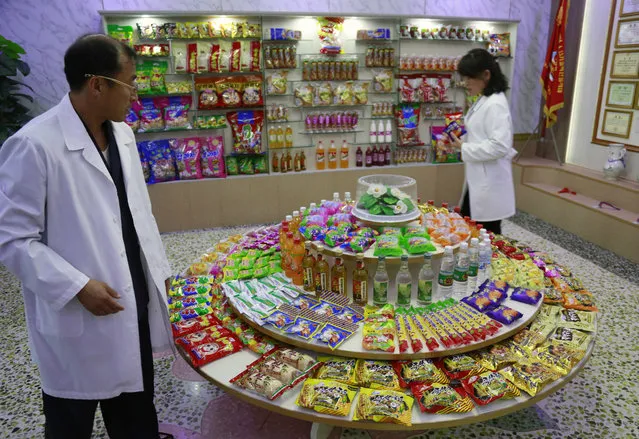 In this October 22, 2018, photo, Kwon Yong Chol, left, the chief engineer at the Songdowon General Foodstuffs Factory, shows samples of products at his facility in Wonsan, North Korea. Though the international spotlight has been on his denuclearization talks with Washington, the North Korean leader has a lot riding domestically on his promises to boost the country's economy and standard of living. His announcement in April that North Korea had sufficiently developed its nuclear weapons and would now focus on building its economy marked a sharp turn in official policy and set the stage for his rapid-fire meetings with the leaders of China, South Korea and the United States. (Photo by Dita Alangkara/AP Photo)