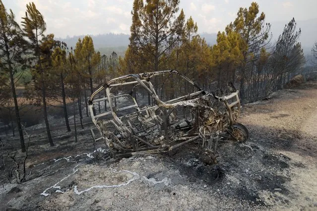 The wreckage of a car burned by a forest fire in Bejis, Castellon, Spain, 17 August 2022. Hundreds of people were evacuated from the area ​as firefighters were still battling the active fire. (Photo by Domenech Castello/EPA/EFE)