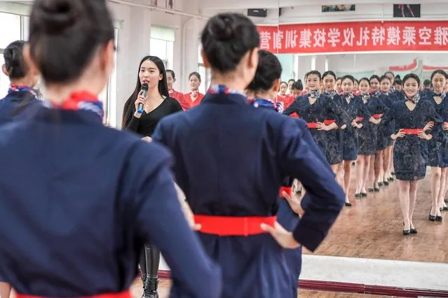 Students attend a stewardess skill training for the upcoming 2017 entrance examination for art majors in colleges in Luoyang, central China's Henan Province, January 4, 2017. The instructor issues her commands though a microphone as her students check their posture in a mirror. (Photo by Li Bo/Xinhua/Barcroft Images)