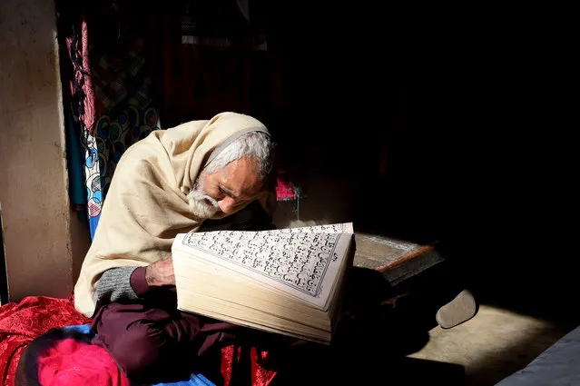 A Pakistani vendor of women garments reads the Koran while waiting for customers at his shop in Lahore on January 15, 2019. (Photo by Arif Ali/AFP Photo)