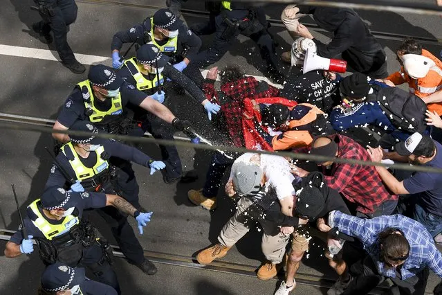 Victoria police fire pepper spray during a clash with protesters at a Rally for Freedom in Melbourne, Australia, Saturday, September 18, 2021. The protesters were demonstrating against the latest COVID-19 lockdown in Melbourne. (Photo by James Ross/AAP Image via AP Photo)