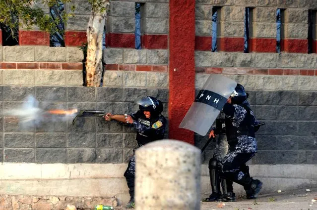 Riot police shoot tear gas at students protesting in Tegucigalpa against the murder of indigenous activist Berta Caceres, in La Esperanza, 200 km northwest of the capital, on March 3, 2016. Caceres, a respected environmentalist who won the prestigious Goldman Prize last year for her outspoken advocacy, was murdered in her home Thursday, her family said. (Photo by Orlando Sierra/AFP Photo)