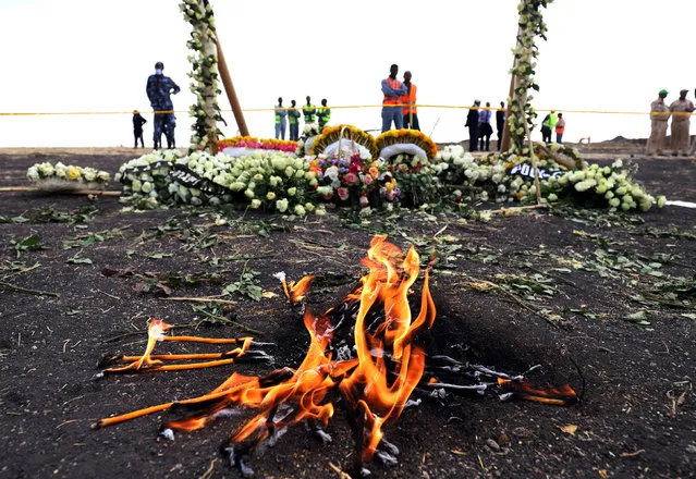 Candle flames burn during a commemoration ceremony for the victims at the scene of the Ethiopian Airlines Flight ET 302 plane crash, near the town Bishoftu, near Addis Ababa, Ethiopia on March 14, 2019. (Photo by Tiksa Negeri/Reuters)