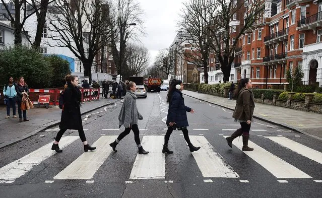 Beatles fans cross the famous Abbey Road zebra crossing to pay their respects to Beatles producer George Martin at Abbey Road Studios in London, Britain, 09 March 2016. George Martin, a British music producer best known for his work with The Beatles during the 1960s, has died aged 90. Martin influenced The Beatles' sound after taking them on when he heard their demo tape in 1962. He is credited with 30 number one singles for The Beatles and other artists. (Photo by Andy Rain/EPA)