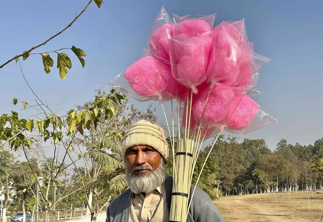 An elderly man poses as he sells cotton candy in Islamabad, Pakistan, Wednesday, January 10, 2024. (Photo by Rahmat Gul/AP Photo)