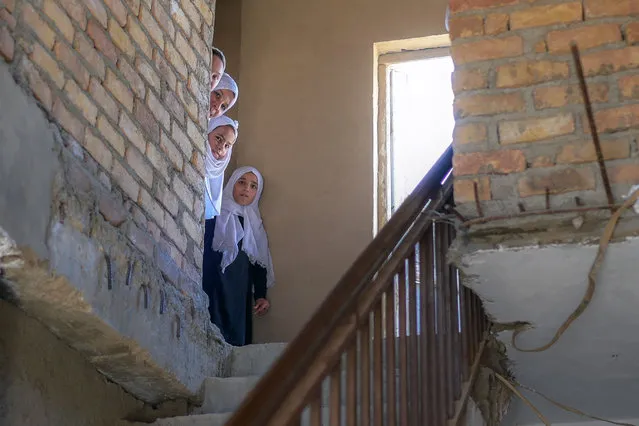 School girls look out after arriving at a gender-segregated school in Kabul on September 15, 2021. (Photo by Bulent Kilic/AFP Photo)