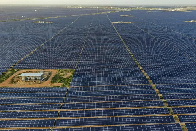 This photo taken on October 6, 2021 shows solar panels at the site of solar energy projects developer Saurya Urja Company of Rajasthan Limited, at the Bhadla Solar Park in Bhadla, in the northern Indian state of Rajasthan. Currently, coal powers 70 percent of the nation's electricity generation, but Indian Prime Minister Narendra Modi pledged on November 1 that it would produce more energy than India's entire grid now through solar and other renewables by 2030. (Photo by Sajjad Hussain/AFP Photo)