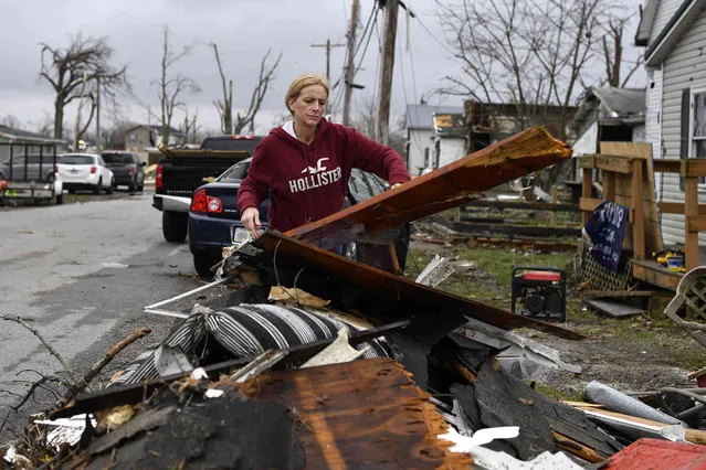 Amber Mangan throws debris on a pile outside her mothers home that was destroyed by severe storms in Lakeview, Ohio., Friday, March 15, 2024. Severe storms with suspected tornadoes have damaged homes and businesses in the central United States. (Photo by Timothy D. Easley/AP Photo)